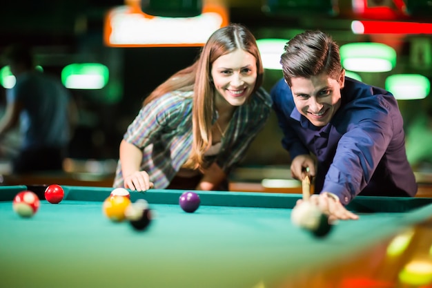 Young couple playing pool