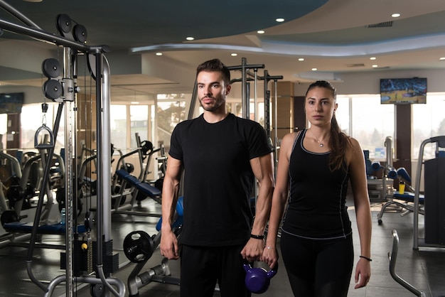 KettleBell과 함께 체육관에서 포즈를 취하는 젊은 부부