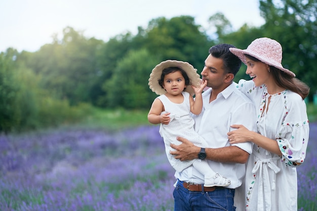 Coppia giovane in posa con il bambino nel campo di lavanda