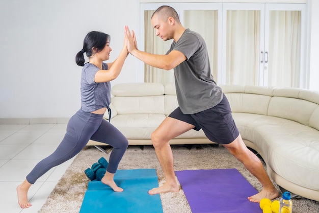 Young couple pushing each other while exercising