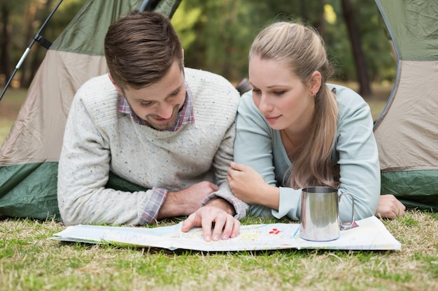 Young couple reading map in tent