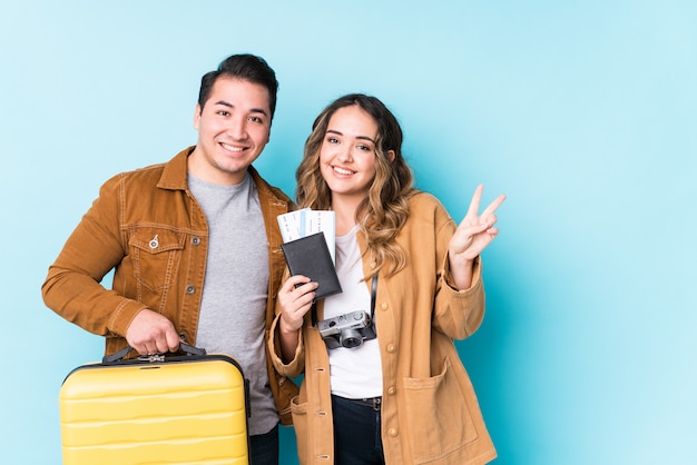 Young couple ready for a travel isolated showing number two with fingers.