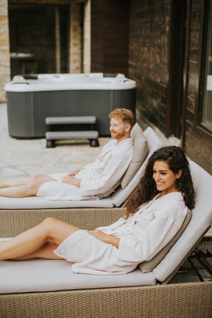 Young couple relaxing on beds on the outdoor terrace