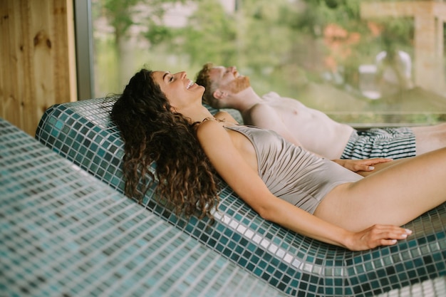 Фото Молодая пара отдыхает на кровати тепидариума в спа-салоне