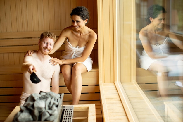 Photo young couple relaxing in the sauna