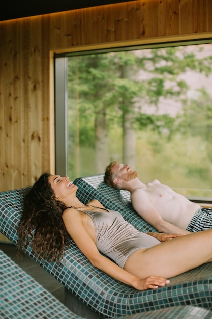 Young couple relaxing on the tepidarium bed in the spa