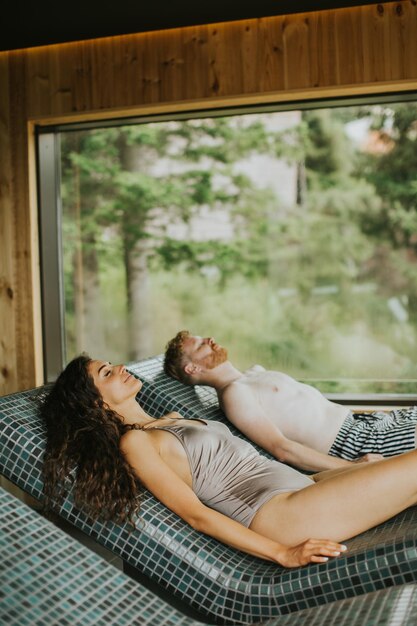 Young couple relaxing on the tepidarium bed in the spa