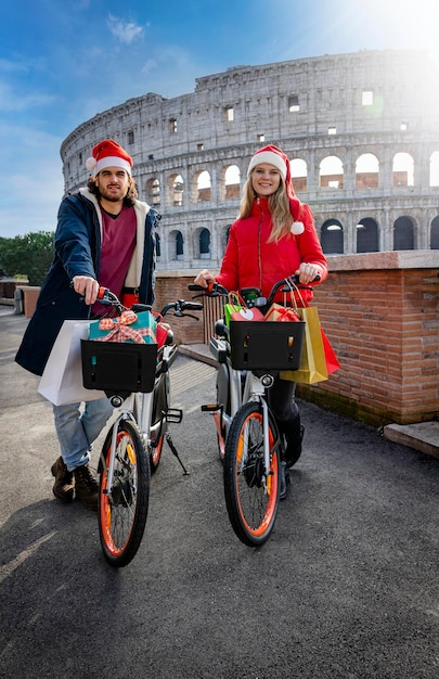 Foto una giovane coppia che si riposa da una giornata di shopping a roma con le biciclette piene di borse e regali