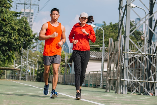 写真 都市公園の道路を実行している若いカップルランナー;スポーツ、人々、運動、ライフスタイルコンセプト