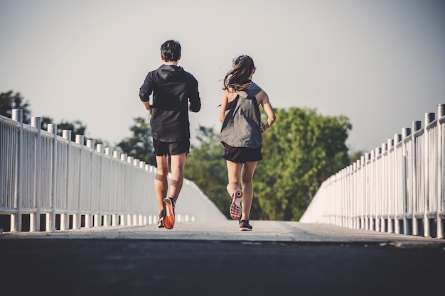 Young couple runner running on running road in city park