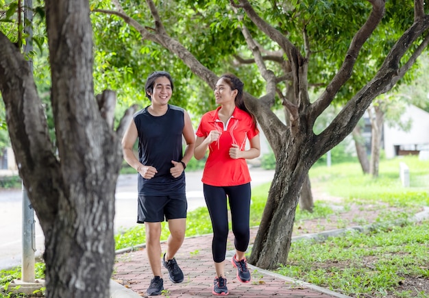 Молодая пара, бегающая по парку, спорт и любовь сочетаются в этой концепции, а спортивный мужчина и женщина тренируются вместе.