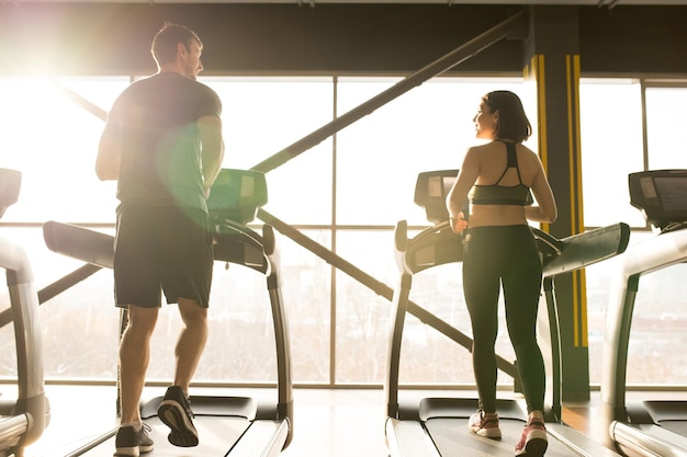 Young couple running on treadmill