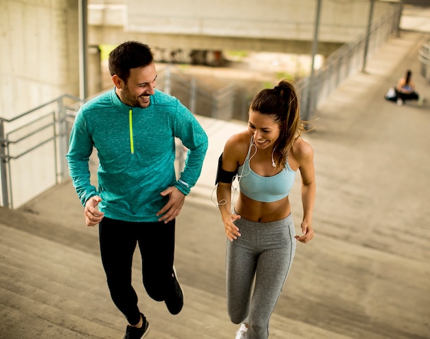 Young couple running  up stairs