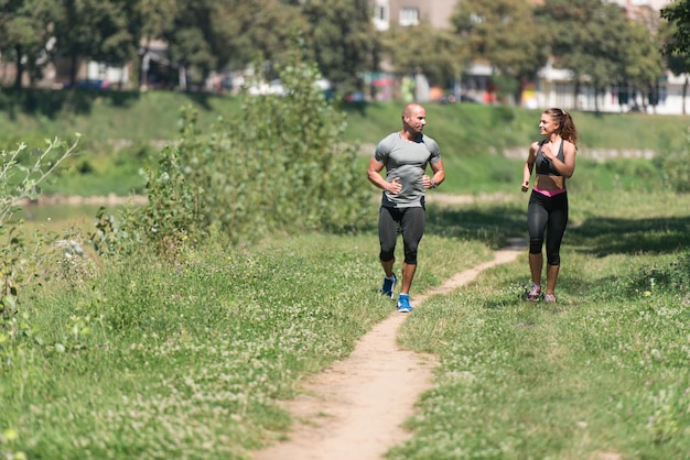 숲이 우거진 숲 지역에서 달리는 젊은 부부 훈련 및 트레일 런 마라톤 지구력 피트니스 건강한 라이프 스타일 개념을 위해 운동