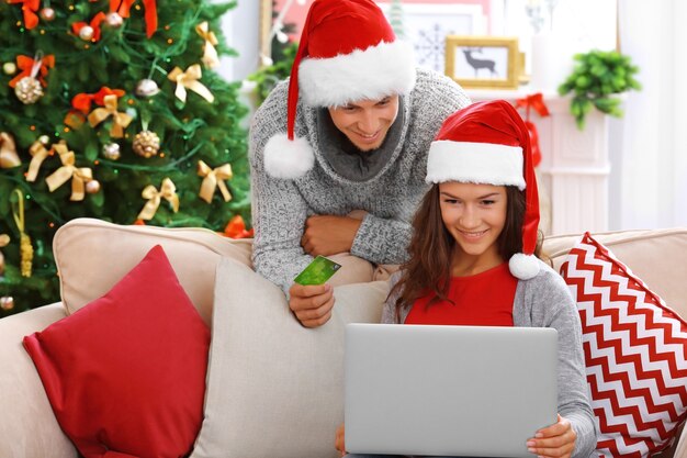 Young couple shopping online with credit card at home for Christmas