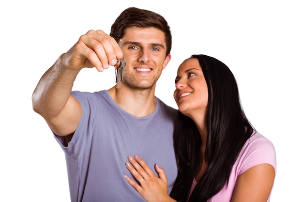 Young couple showing keys to house