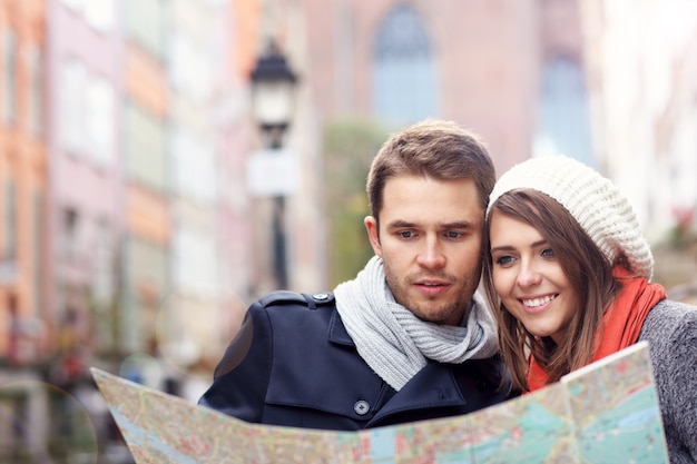 young couple sightseeing with map