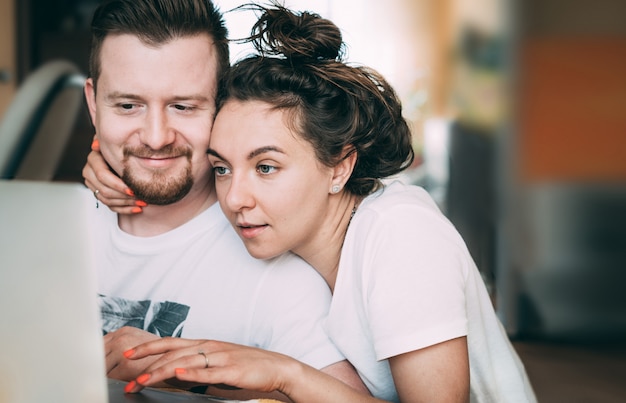 A young couple sits at home and plans their purchases and wedding.