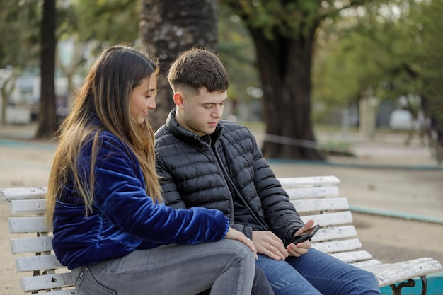 Young couple sitting on the bench in a square