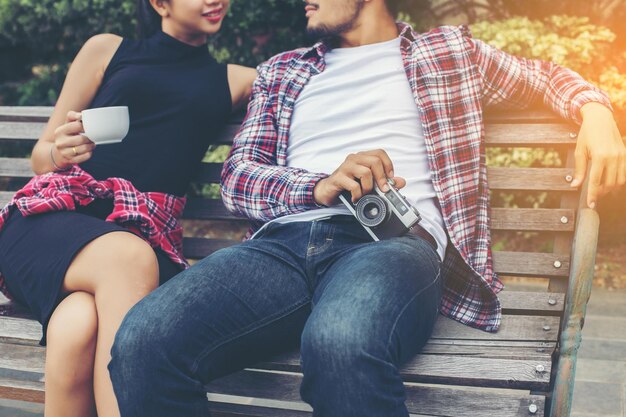 Photo young couple sitting on bench