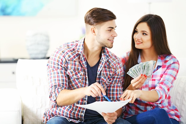 Young couple sitting and calculating bills at home