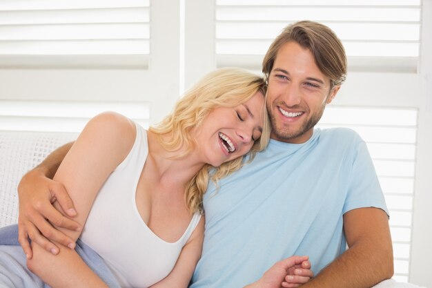 Young couple sitting on the couch laughing