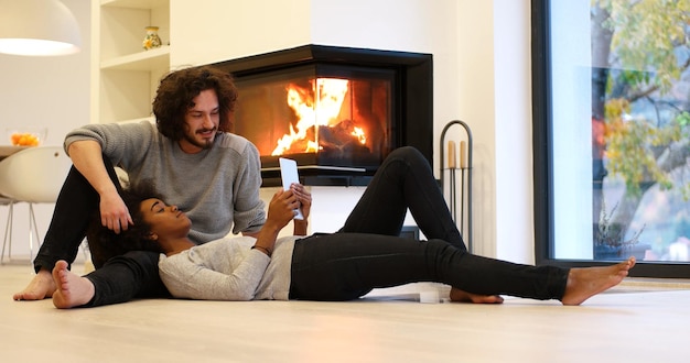 Young Couple sitting on the floor and using interent on digital tablet