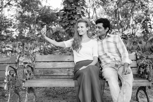 Photo young couple sitting outdoors