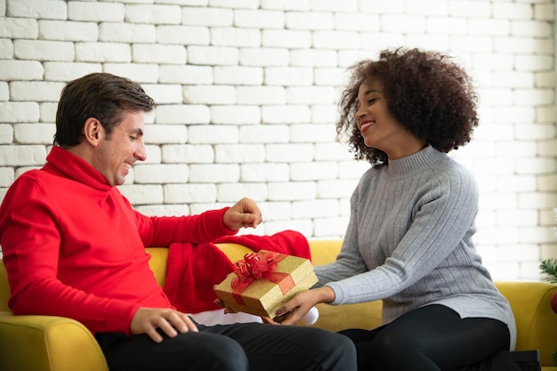 Photo young couple sitting on red wall