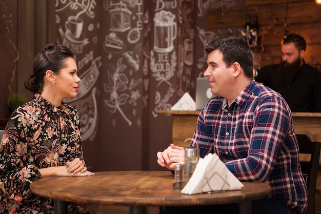 Young couple sitting in a restaurant talking and having a good time.