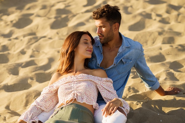 Young couple sitting on sand