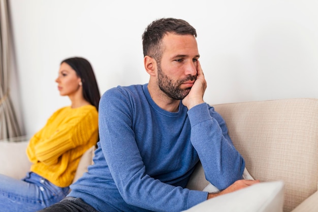 Photo young couple sitting on sofa being angry after fight couple having argument at home girlfriend and boyfriend sitting next to each other angry couple fighting