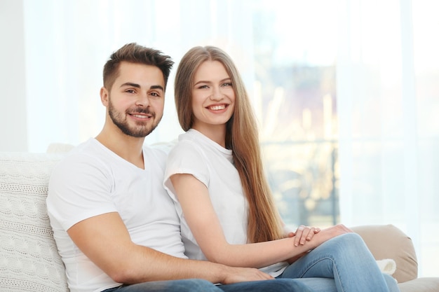 Young couple sitting on sofa at home