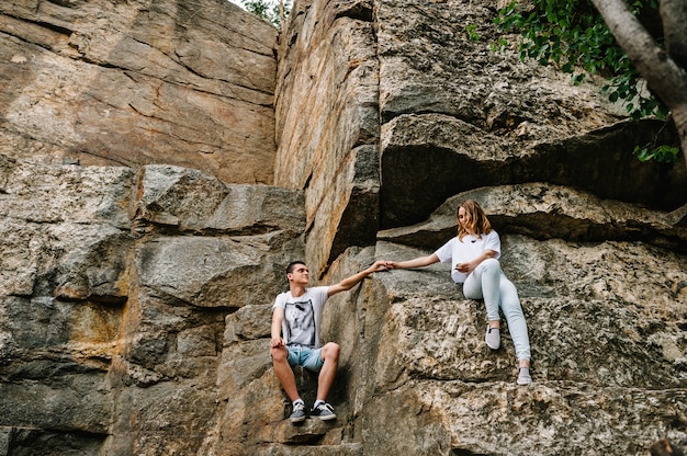 Young couple sitting on stone wall