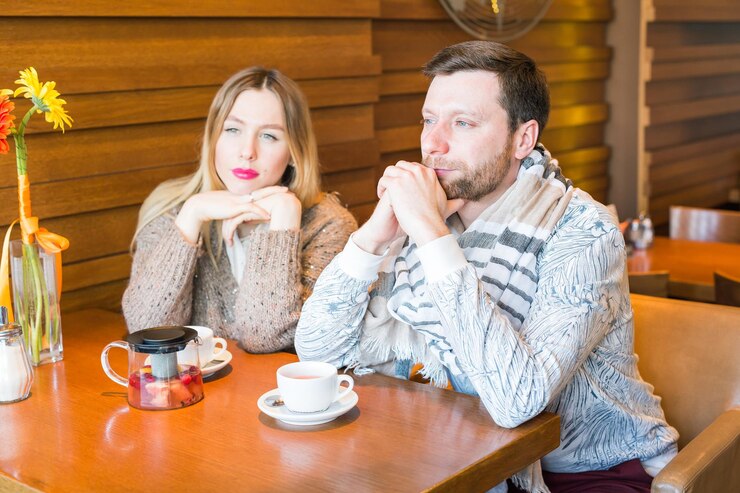 Photo young couple sitting on table at cafe