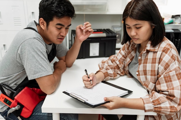 Photo young couple sitting on table