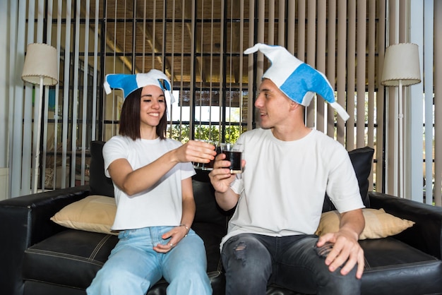 young couple sitting on their couch at home watching a football game