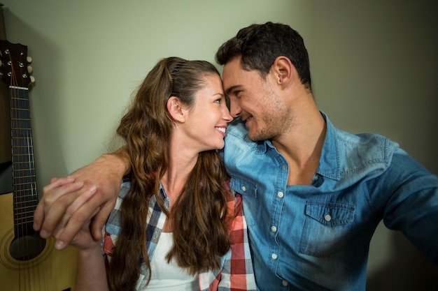 Young couple sitting together on the floor and smiling in their new house