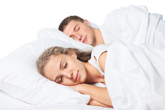Молодая пара спит на кровати в спальне