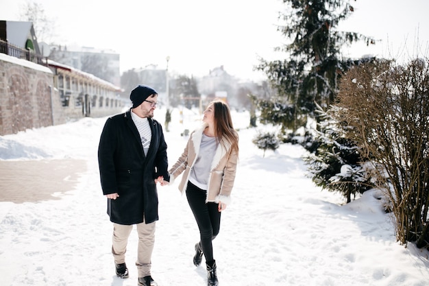 若いカップルは笑顔と冬の公園でキス