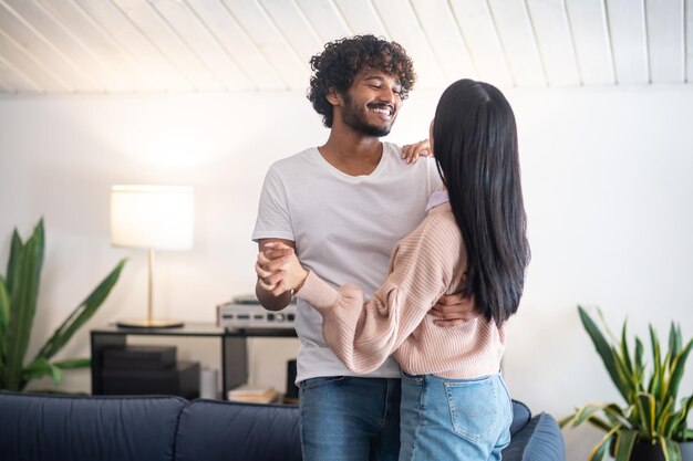 A young couple smiling and dancing in the room