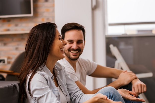 Young couple smiling and having fun at home