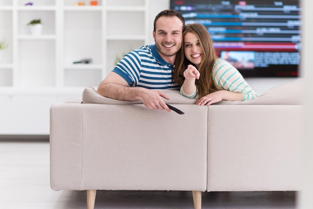 Foto giovane coppia sul divano che guarda la televisione