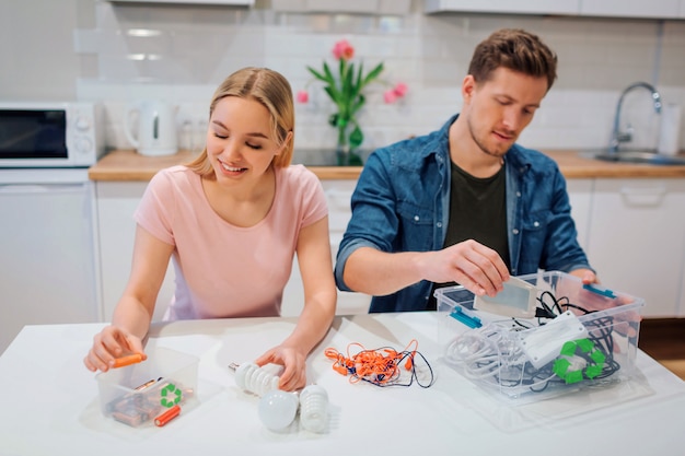 Young couple sorting batteries