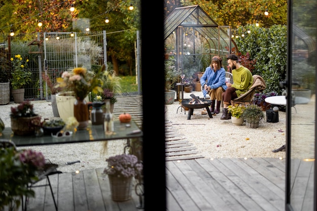 Young couple spending dinner time by the fire at backyard