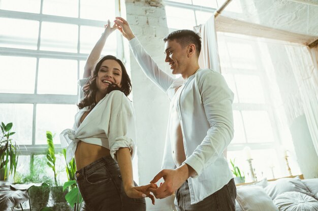 Young couple spending time and dancing in their beautiful countryside house