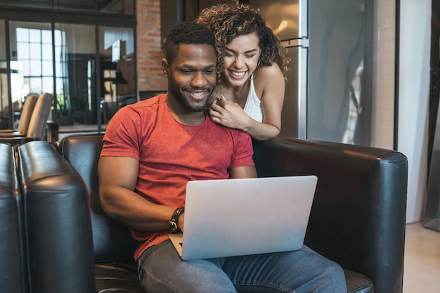 Young couple spending time together while using a laptop at home.