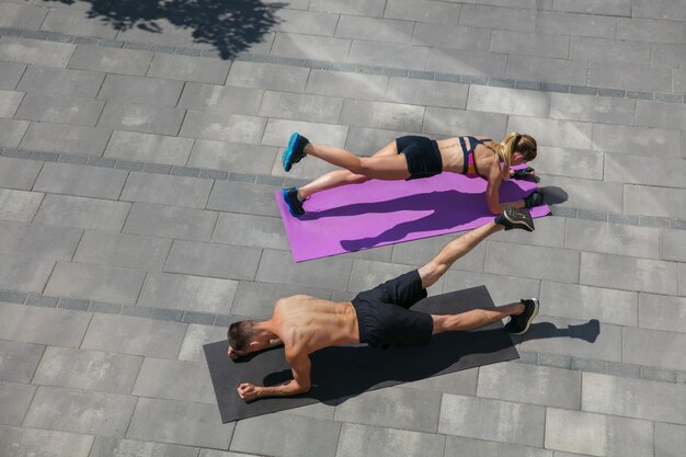 Young couple in sports outfit doing morning workout outdoors, healthy lifestyle