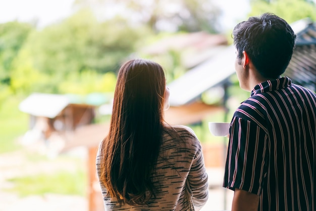 A young couple standing back together