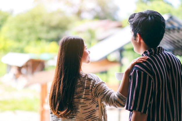 A young couple standing back together